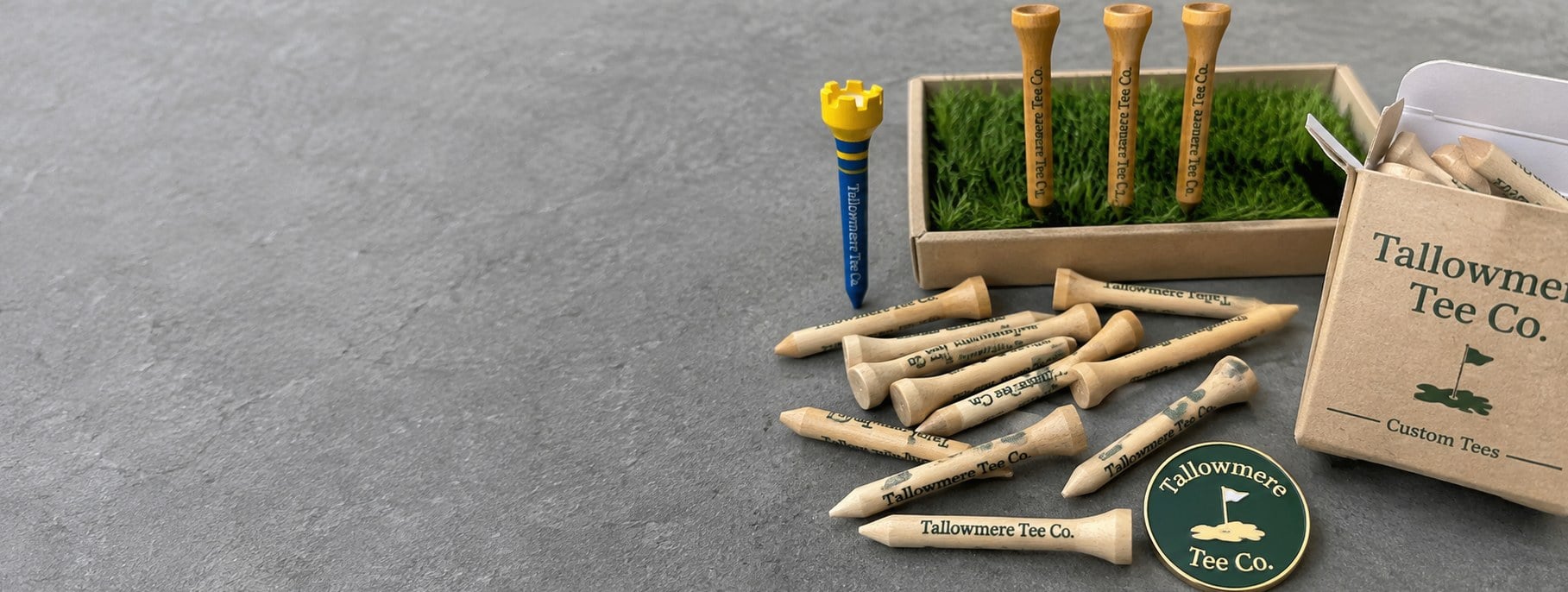 Custom printed golf tees, markers and tee packs on a studio surface